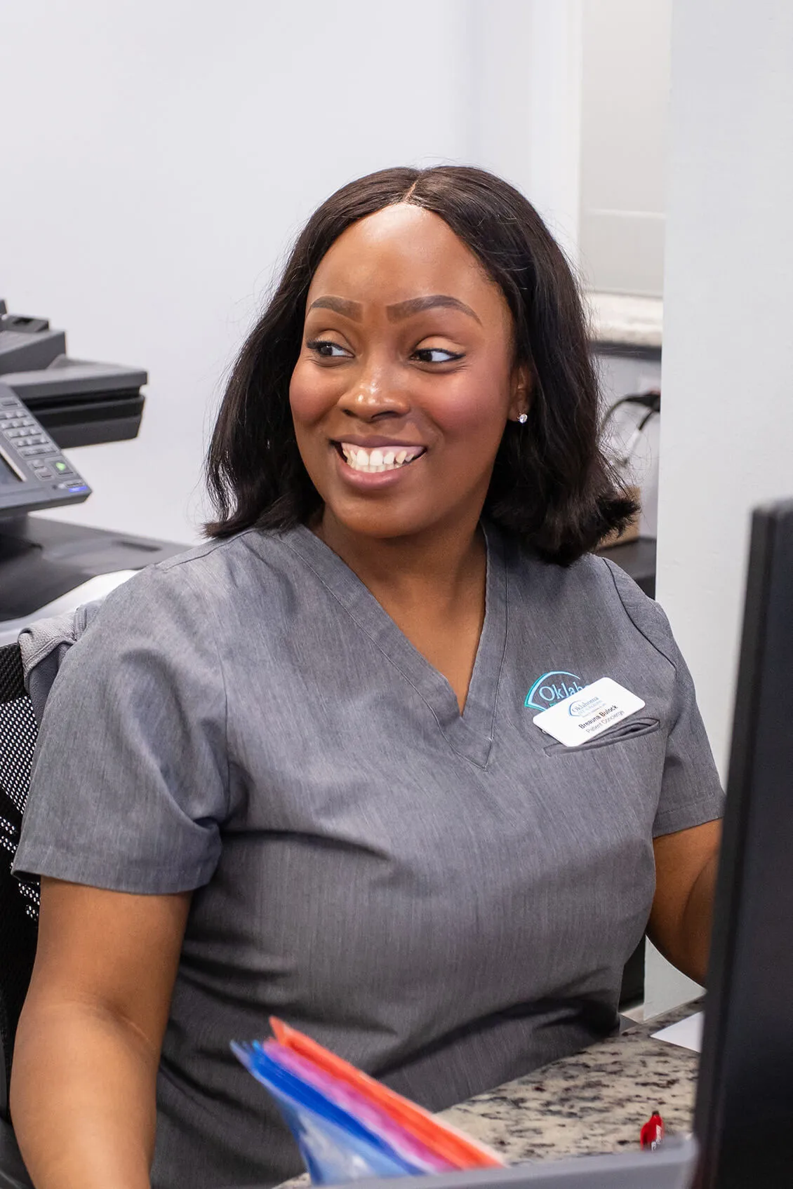 Clinic Receptionist smiling at patient