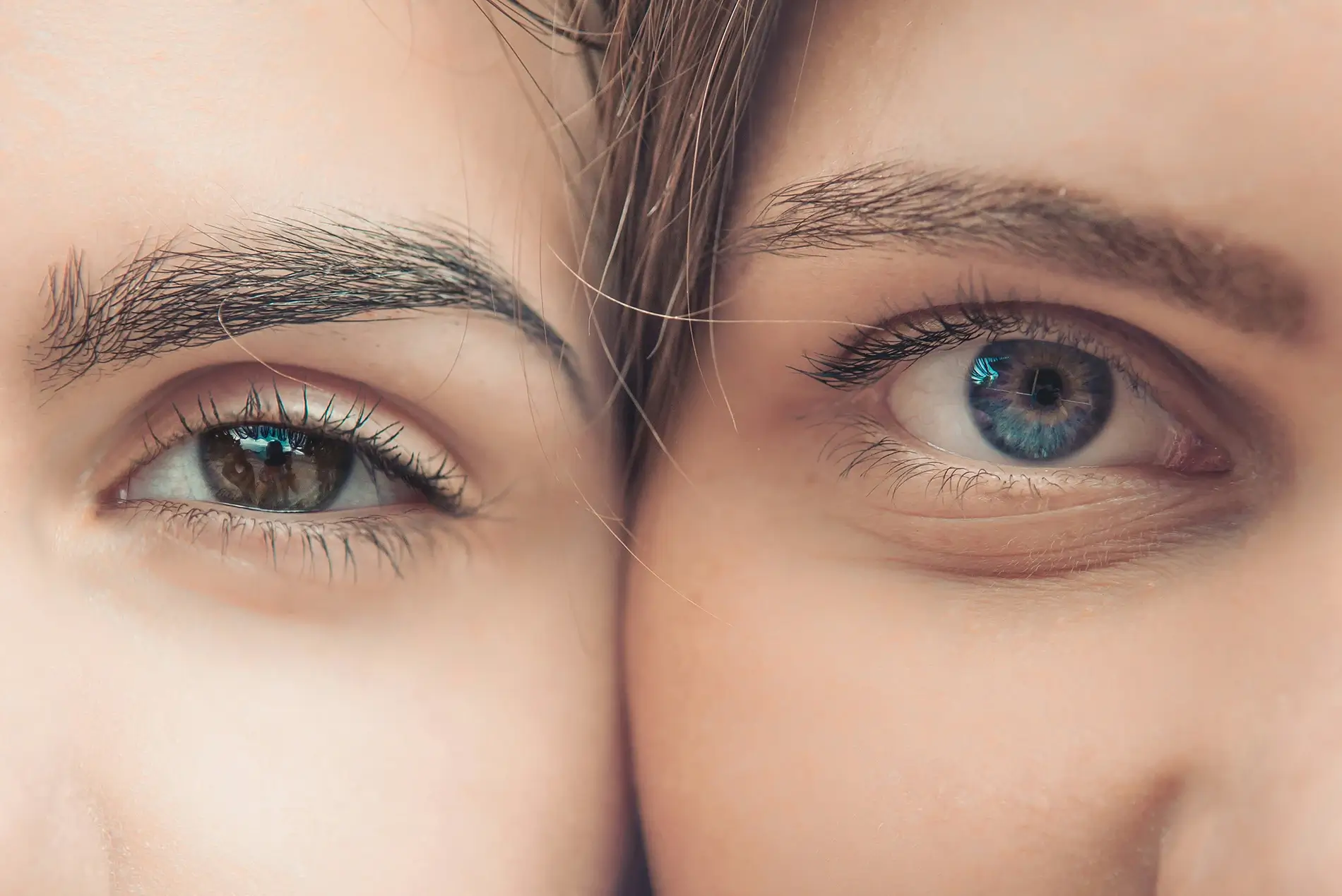 Close up of two women with brown and blue eyes